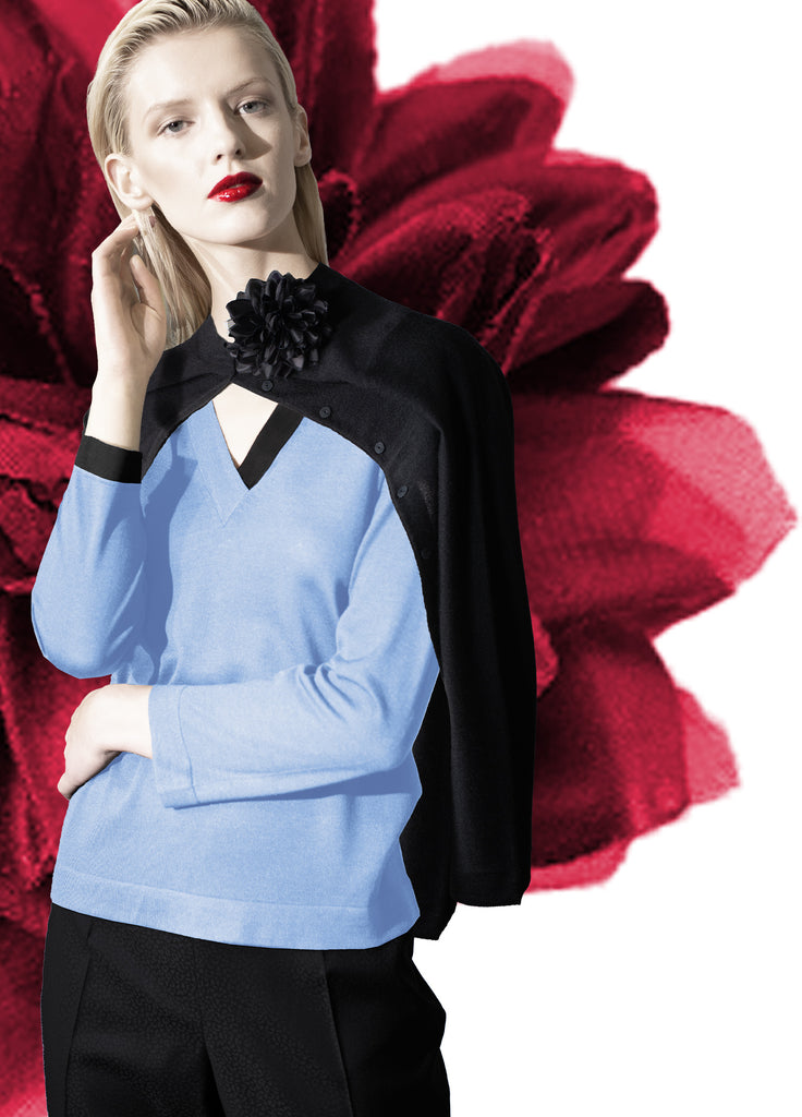cashmere black crew neck cardigan with detachable silk flower on model over blue v-neck