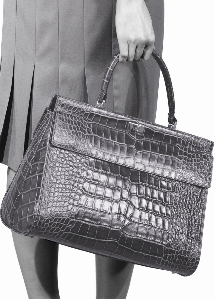 Model holding croc embossed leather single handle bag